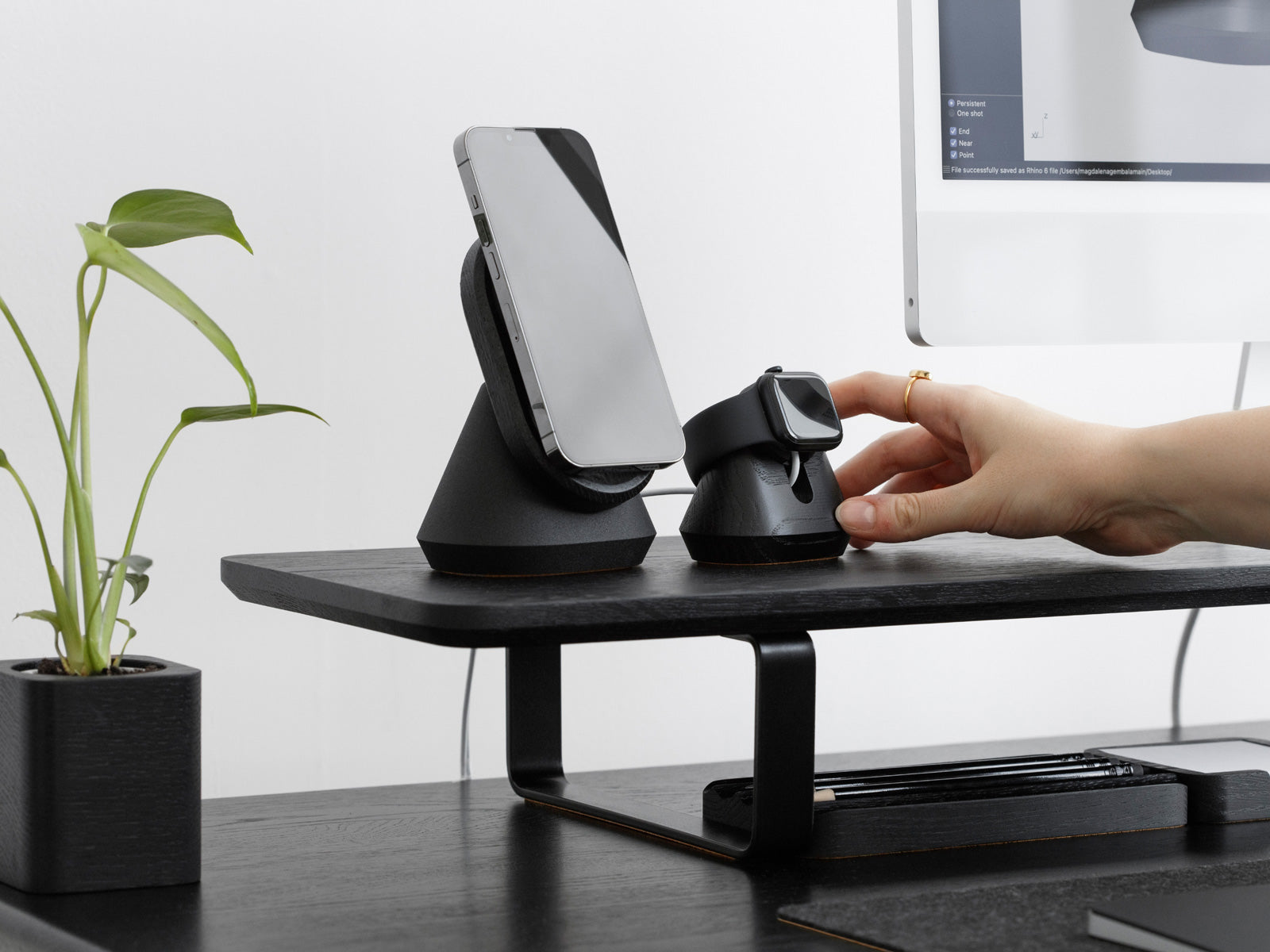 black magnetic charging apple watch stand and magsafe iphone stand on a desk shelf | -